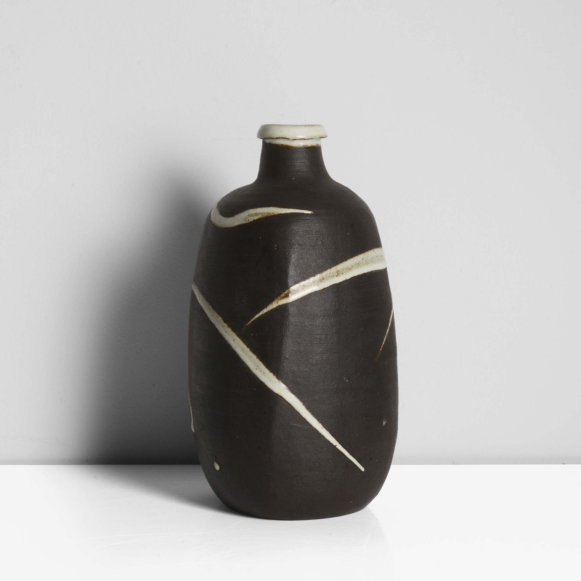 Janet Leach | Stoneware, dry dark brown body with white splashes around the body, and white glaze to the interior and rim, impressed JL and Leach Pottery seals