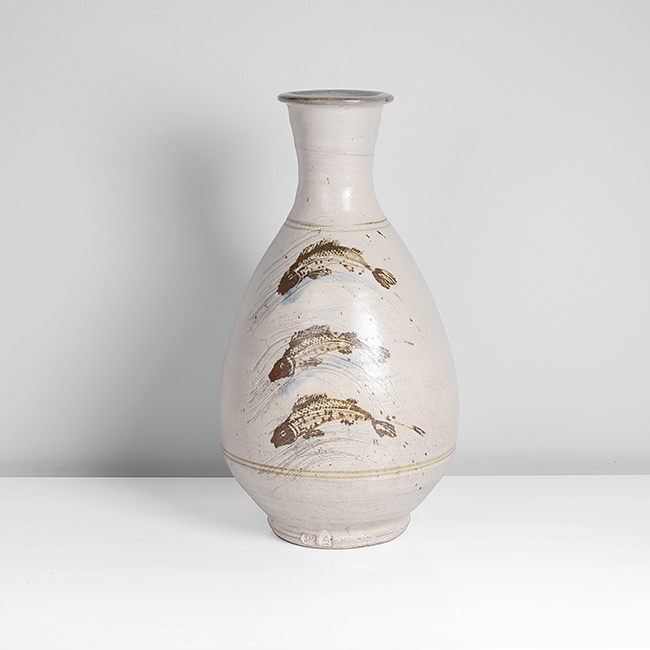 Maak | Jim Malone Stoneware, thickly brushed cream glaze painted and incised with three leaping fish to one face in iron and blue cobalt, impressed JIM and Ainstable Pottery seals