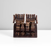 Stoneware Ceramic, dry brown glaze over intricately carved surface, the rectangular chest form set with eight small drawers, the top row of drawers with lids in the form of huts and towers mounted with a bird, beast, crescent moon and boat, the lower row set are carved with beasts made by Ian Godfrey