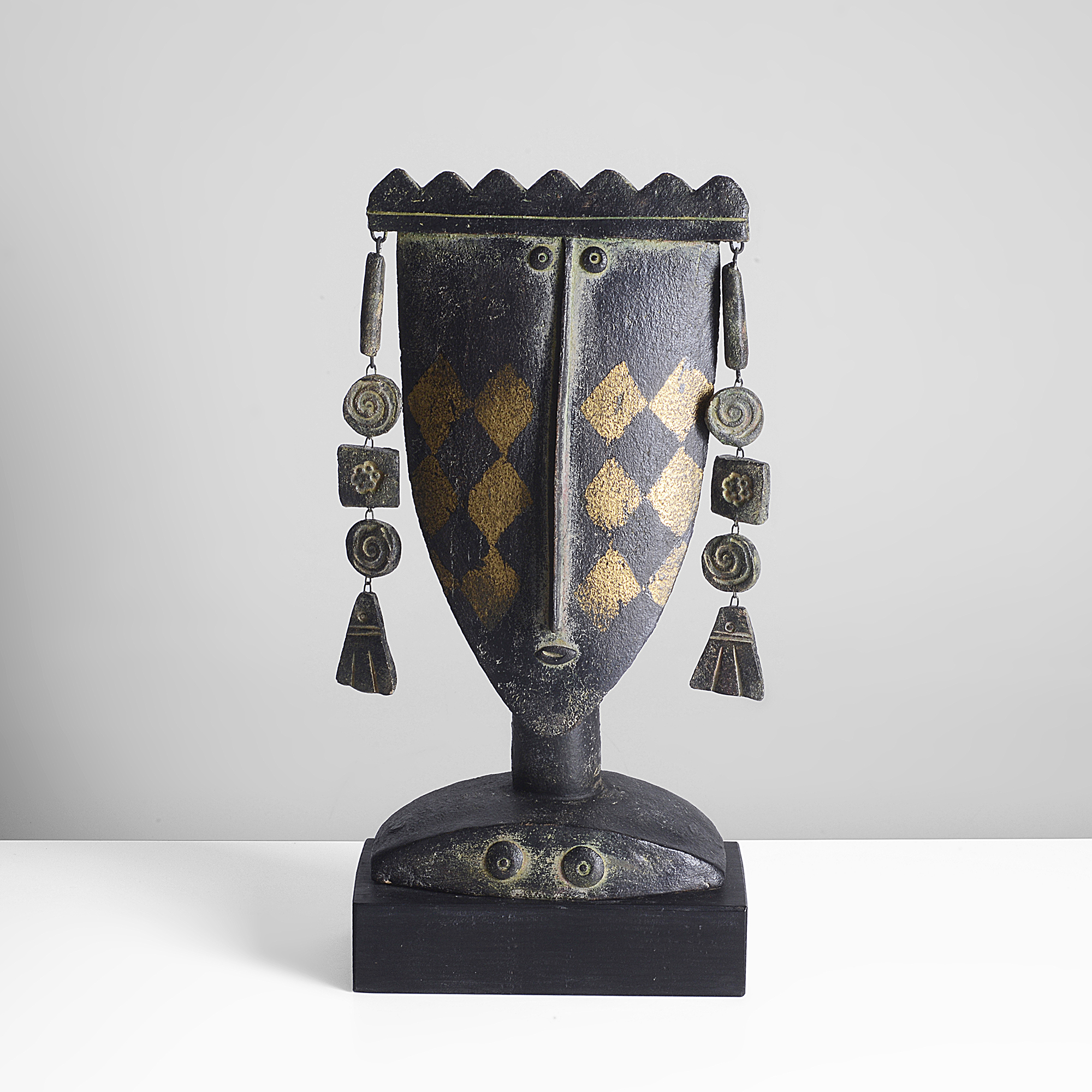 Maak | John Maltby ceramic stoneware, dark grey glaze highlighted in gold, figure head of a queen with crown set with articulated earrings, mounted on a wooden plinth, impressed makers mark, painted title and signature