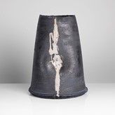 A black stoneware tapered vessel made by Dan Kelly in circa 2002 sold at auction by Maak Contemporary Ceramics