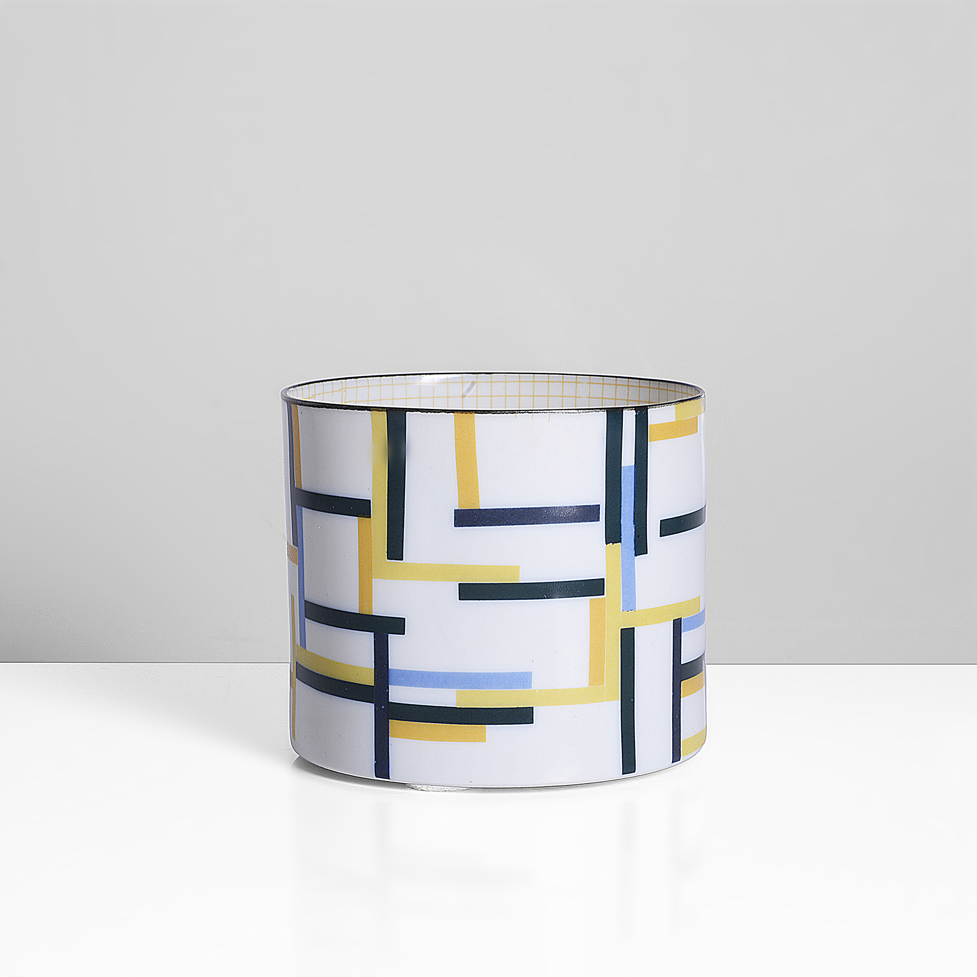 A porcelain cylinder with blue, black and yellow design made by Bodil Manz sold at auction by Maak