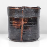 Raku, dark brown mottled glaze with lustrous copper flashes, the glaze thinning to rust red at the edges, the flat topped lid with impressed thumb prints at four points with an incised line running down the edge and down the body, impressed IR and date seals